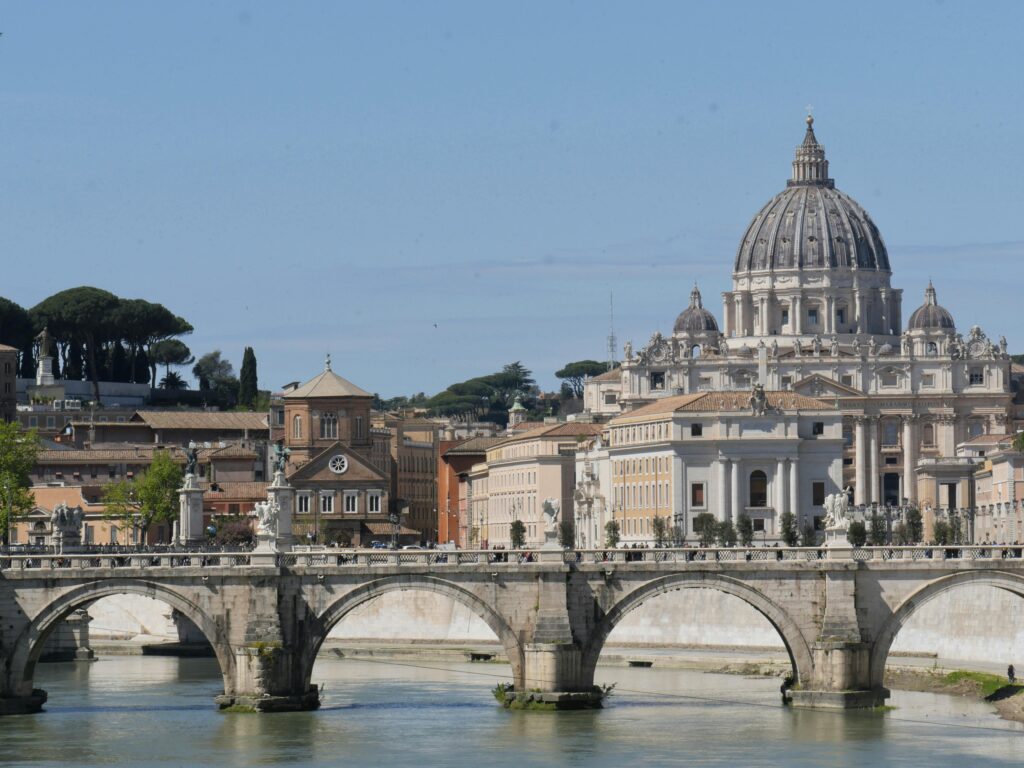 View of St. Peter's Basilica behind Angels Bridge over the Tiber River, Rome.
