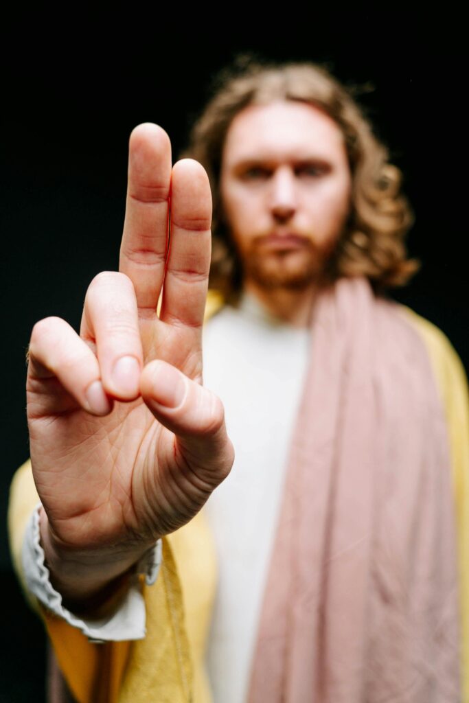 Focus on a man in a religious costume, making a blessing gesture.